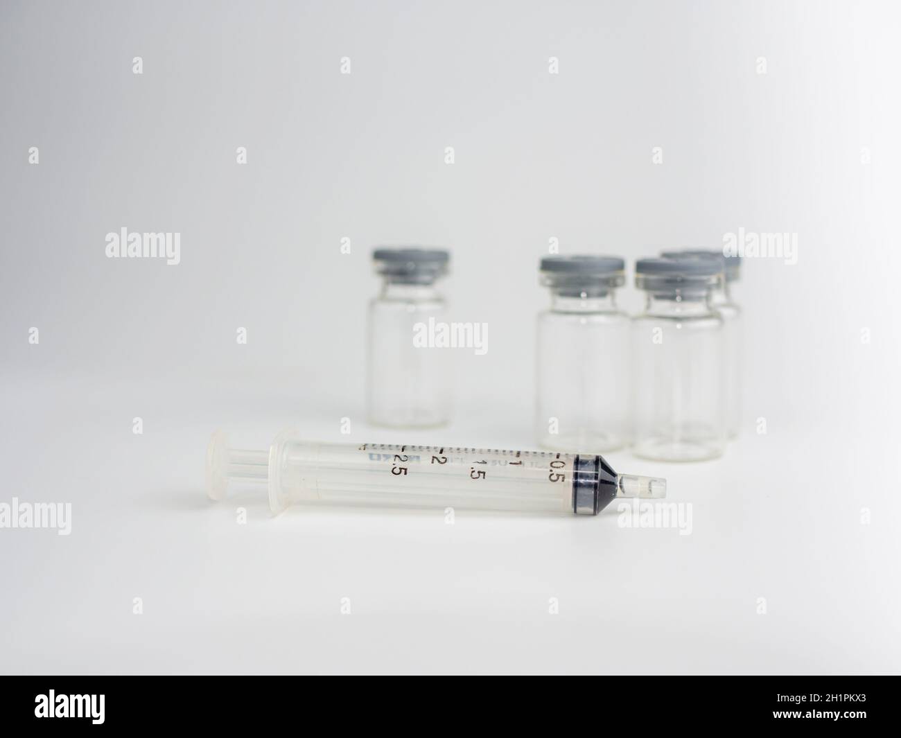 Spritze und Impfstoffflasche auf weißem Hintergrund Stockfoto