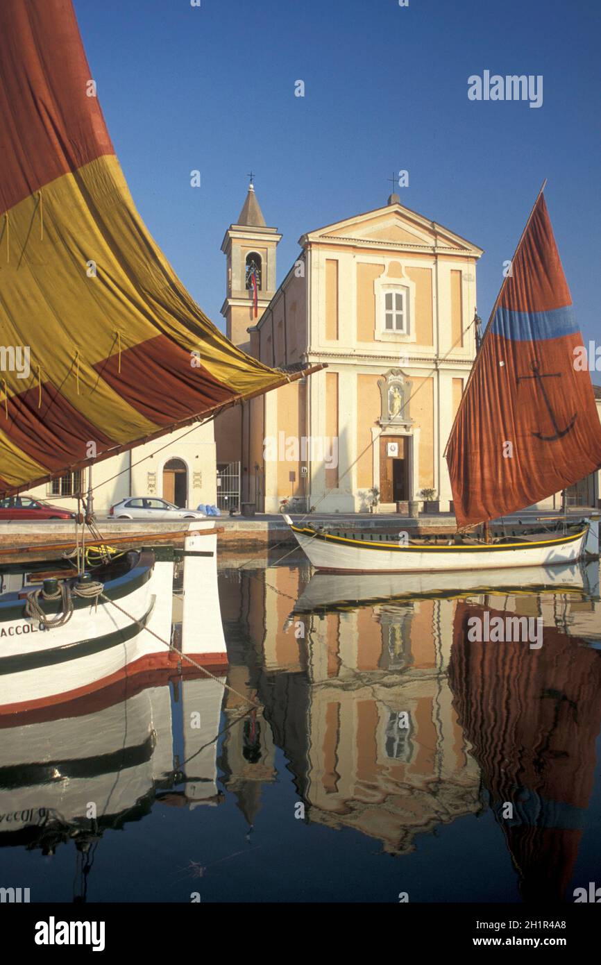 Traditionelle Fischerboote am canale porto mit der Kirche des Heiligen Jakobus in der Stadt Cesenatico in Emilia-Romagna in Italien. Italien, Cesenatico Stockfoto