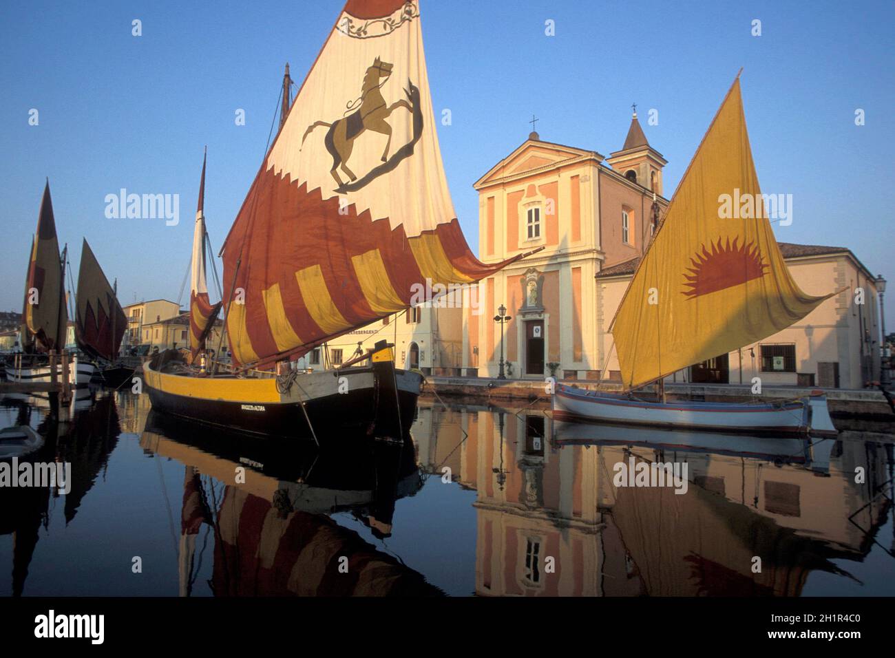 Traditionelle Fischerboote am canale porto mit der Kirche des Heiligen Jakobus in der Stadt Cesenatico in Emilia-Romagna in Italien. Italien, Cesenatico Stockfoto