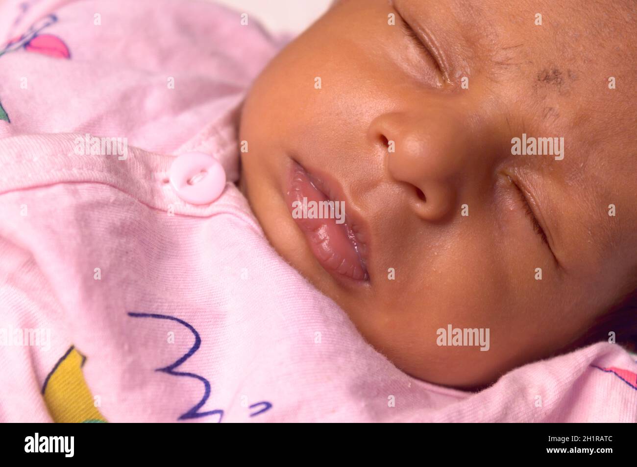 Extreme Nahaufnahme Gesicht eines niedlichen schlafen neugeborenes Baby. Nahaufnahme Porträt eines süßen einen Monat alten Kleinkind Jungen gefangen in schläfriger Stimmung. Vorderansicht. Stockfoto