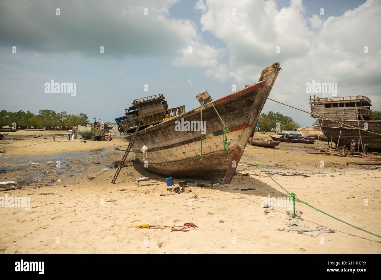 Ein altes Fischerboot wird im Hafen von mehreren Arbeitern repariert. Stockfoto