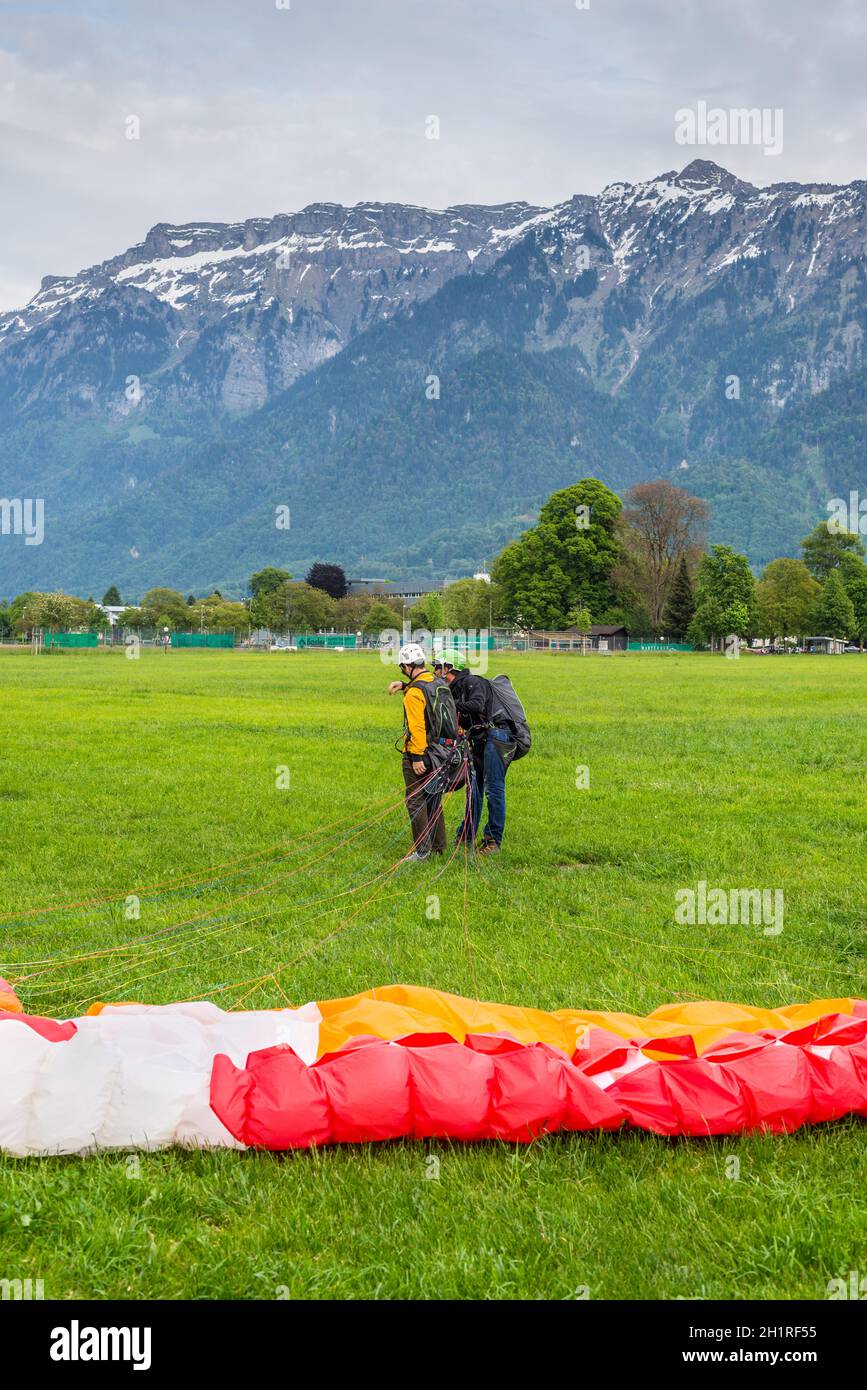 Interlaken, Schweiz - 26. Mai 2016: Tandem-Gleitschirm nach der Landung vor dem Hintergrund der Schweizer Alpen in Interlaken, Schweiz. Stockfoto