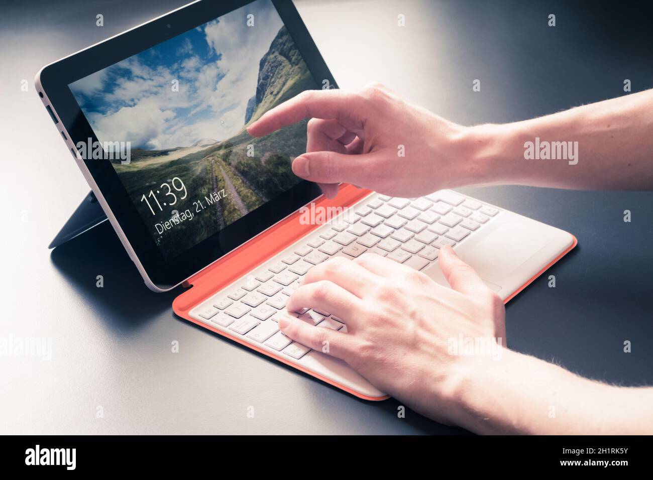 Männliche Hände und weiß orange Convertible Notebook Stockfoto