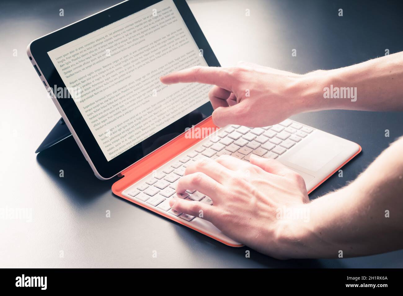 Männliche Hände und weiß orange Convertible Notebook Stockfoto