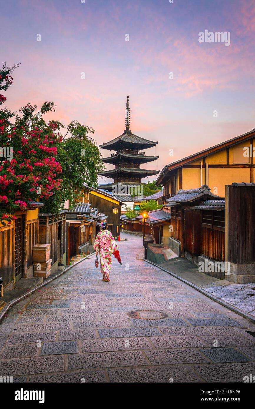 Japanisches Mädchen in Yukata mit rotem Regenschirm in der Altstadt von Kyoto, Japan Stockfoto