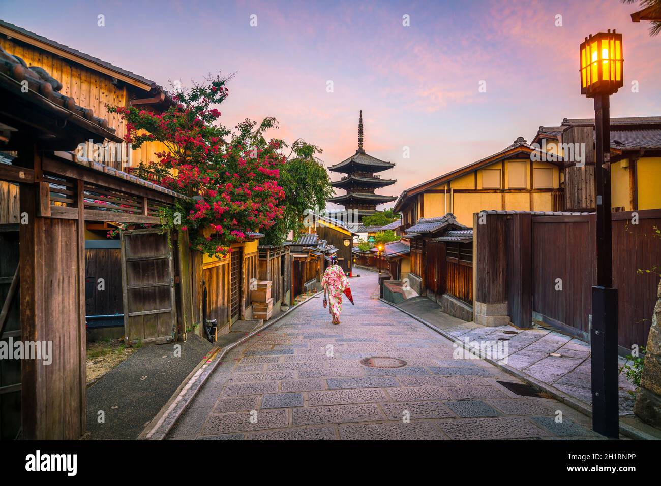 Japanisches Mädchen in Yukata mit rotem Regenschirm in der Altstadt von Kyoto, Japan Stockfoto