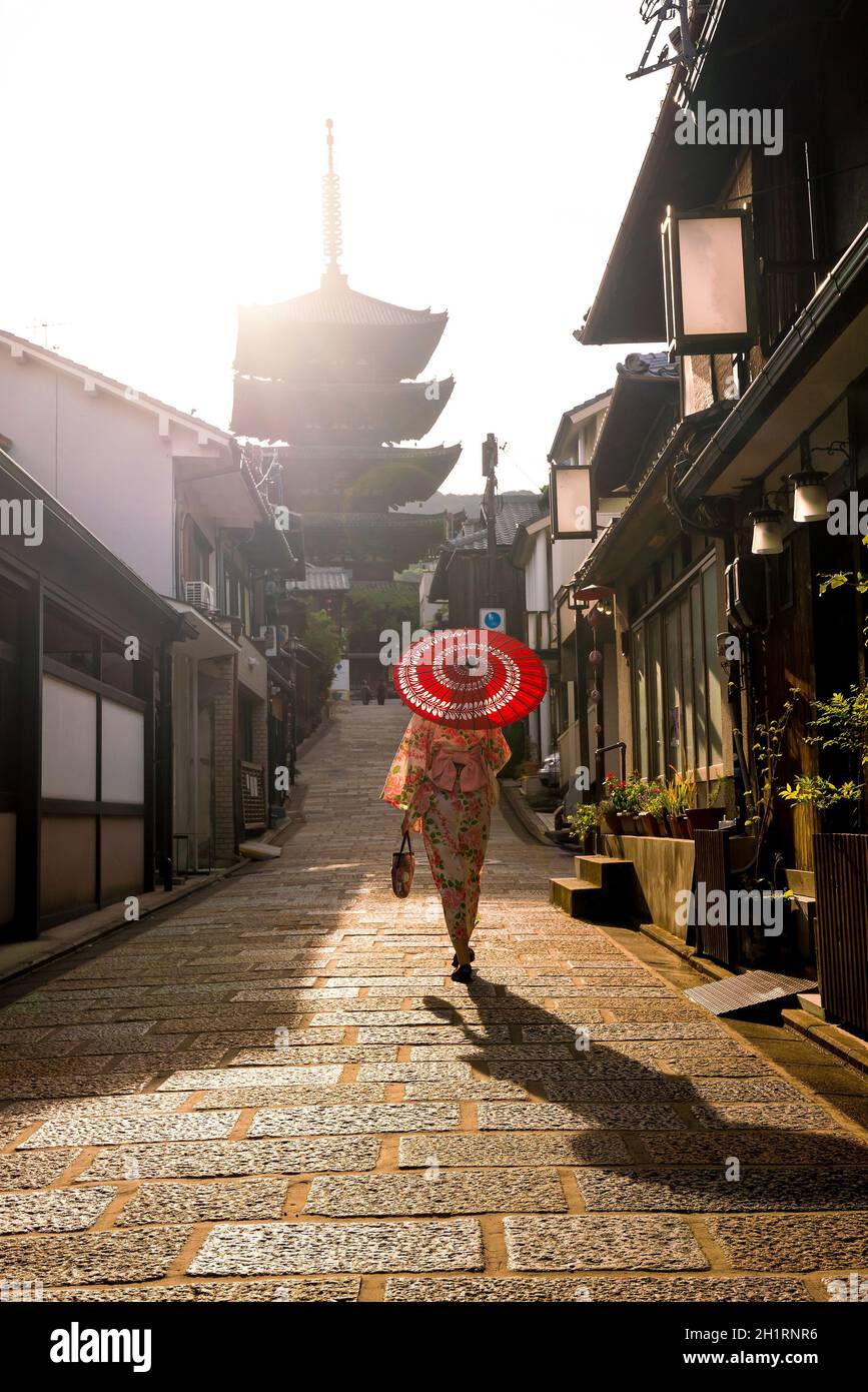 Japanisches Mädchen in Yukata mit rotem Regenschirm in der Altstadt von Kyoto, Japan Stockfoto