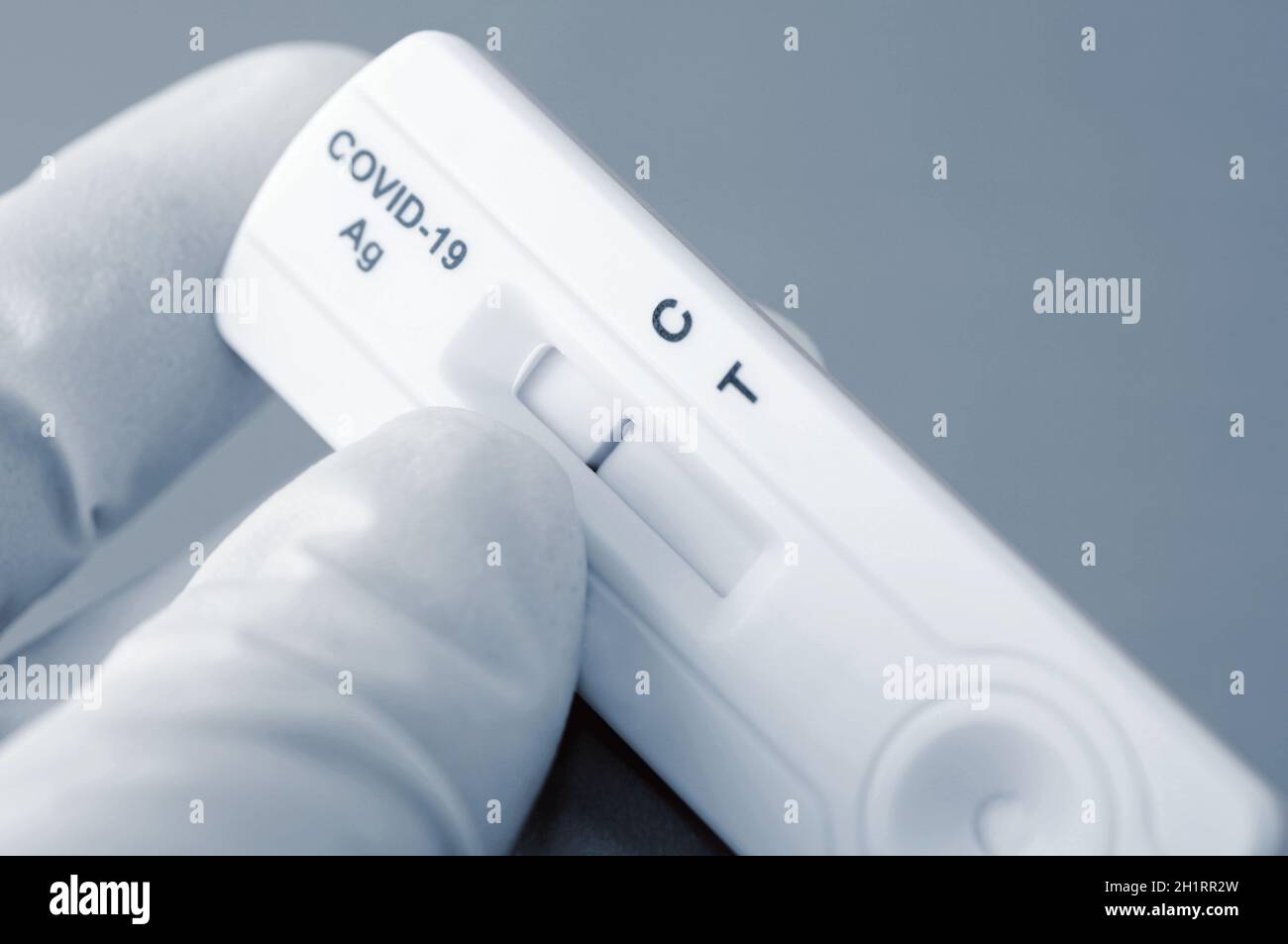 Hand in medizinische Handschuhe hält negativen Antigen-Schnelltest für die Erfassung von COVID-19-Antikörpern. Es zeigt ein negatives Ergebnis. Stockfoto