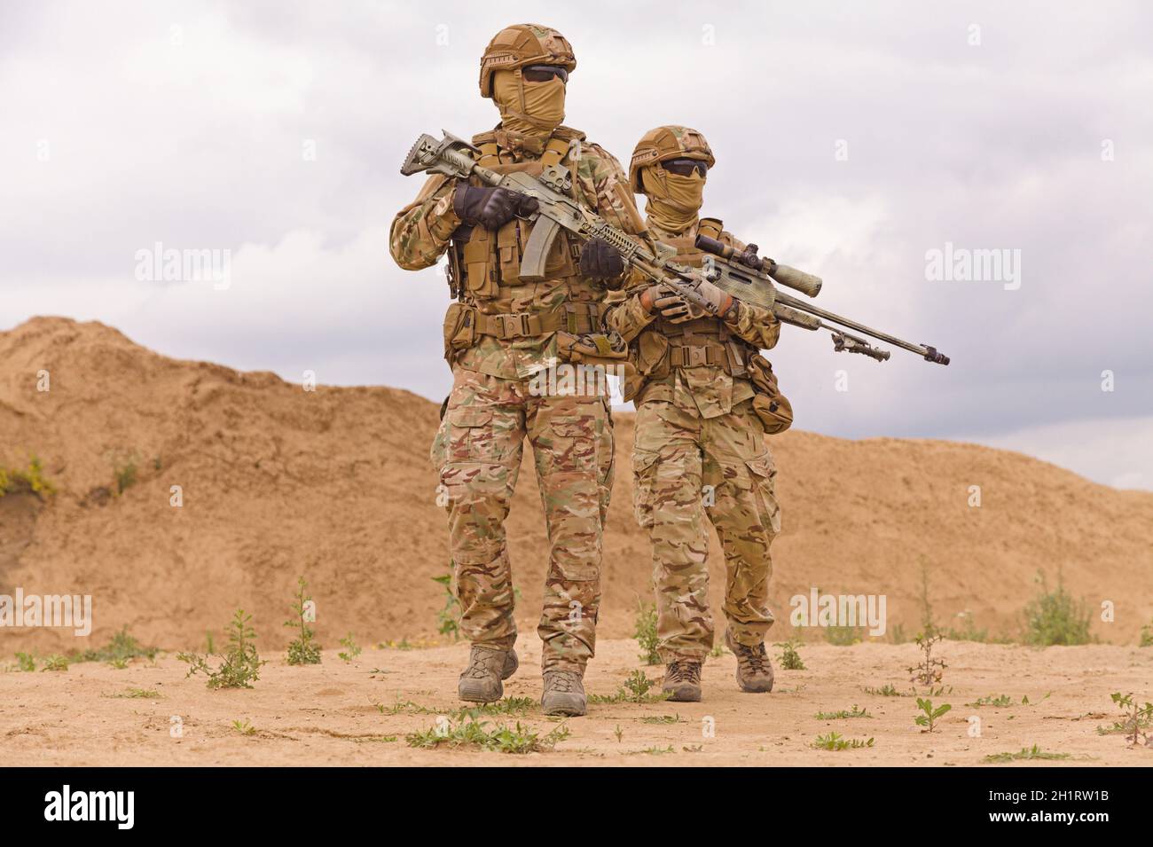Bewaffnete und bewaffnete Soldaten der Spezialeinheiten in der Wüste. Konzept der militärischen Operationen. Stockfoto