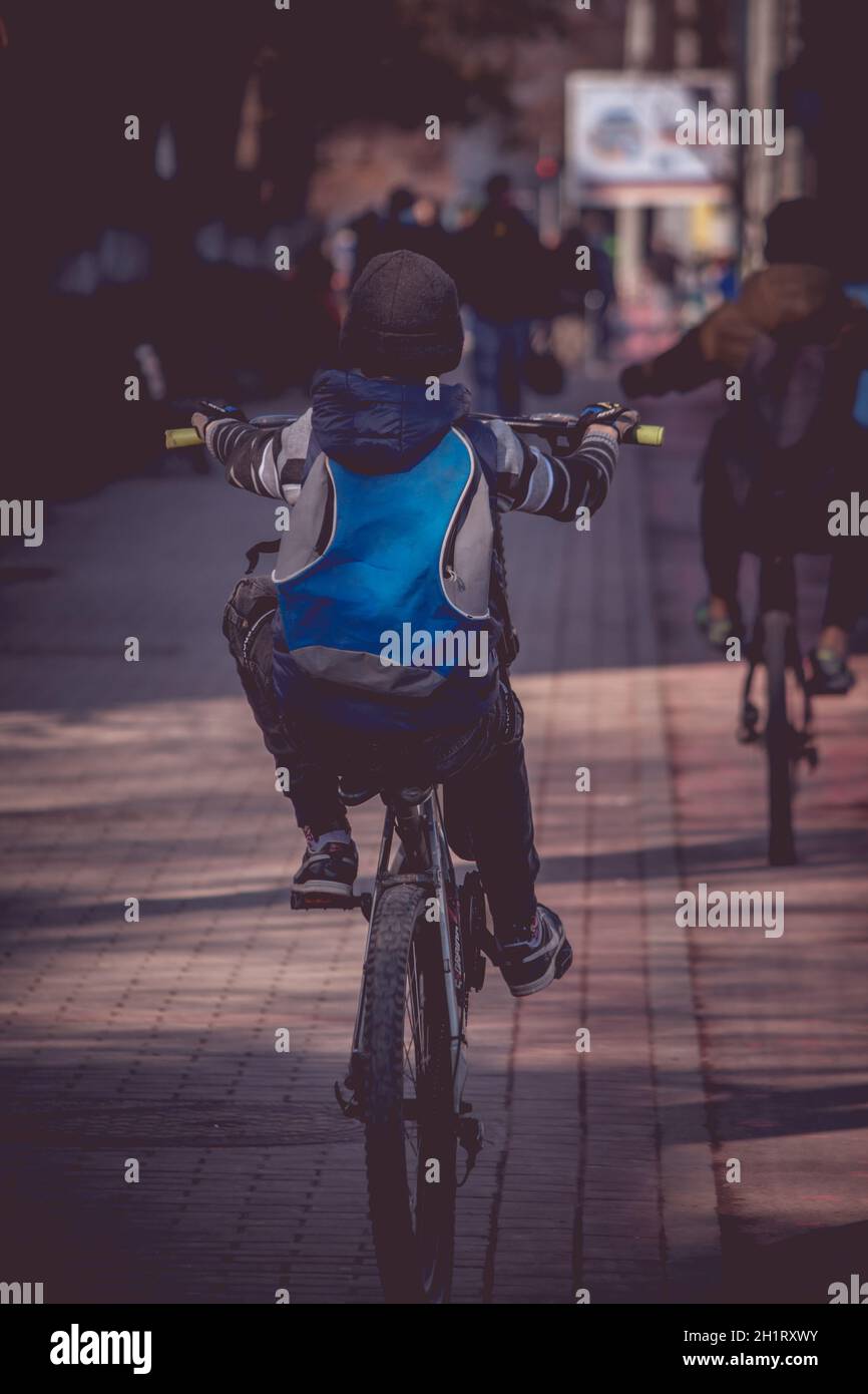 Kleiner Junge, der mit seinem Fahrrad auf dem Bürgersteig einen Wheelie  macht Stockfotografie - Alamy