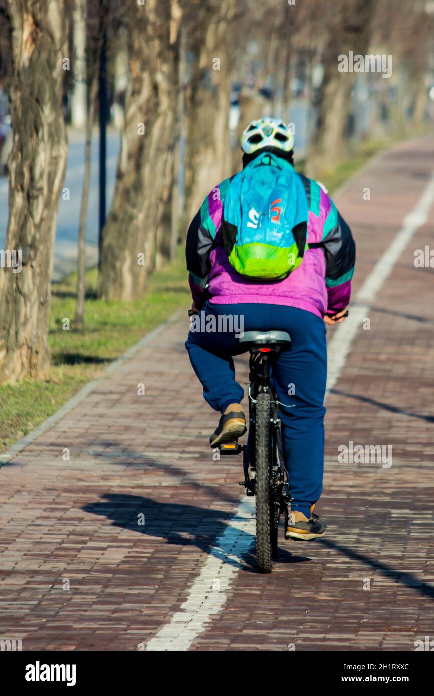 Iasi - Rumänien - 13. März 2021: Person, die an einem sonnigen Tag mit dem Fahrrad auf dem Bürgersteig fährt Stockfoto