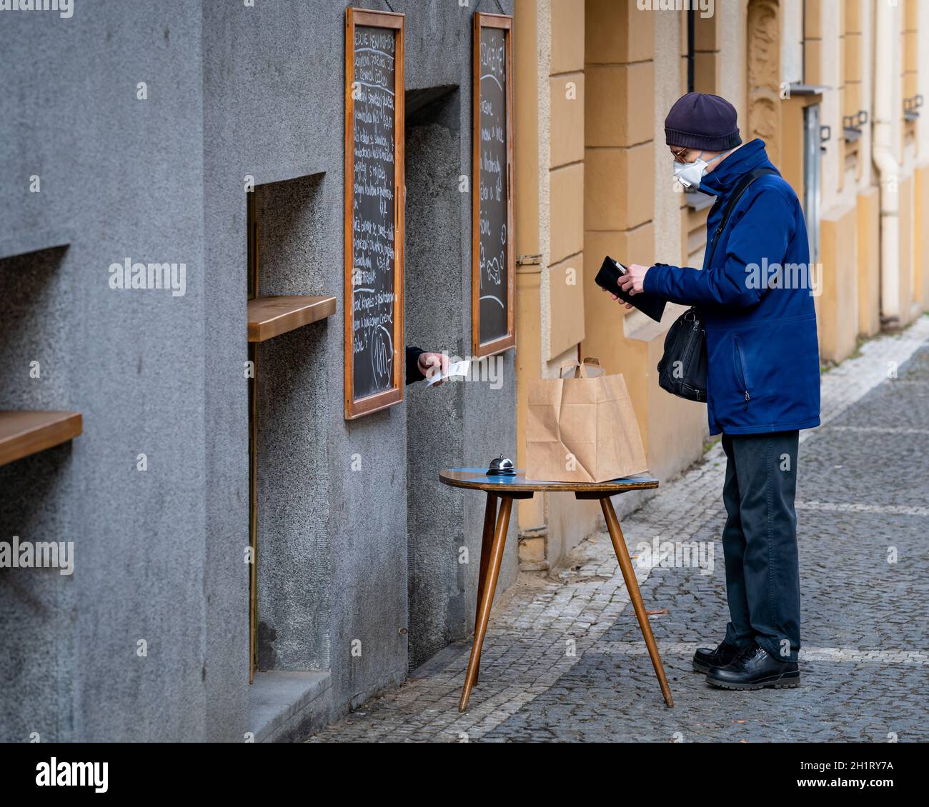 PRAG - 24.02.2021, Abgabe von Lebensmitteln durch das Fenster während der Coronavirus Sperrzeit. Stockfoto
