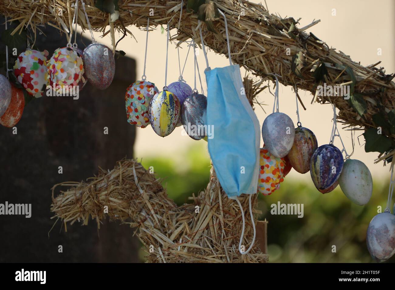 Mund- und Nasenschutz und bunte Hier an einer Strohskulptur von Hausen an der Möhlin Themenbild Medizin - Coronavirus Stockfoto