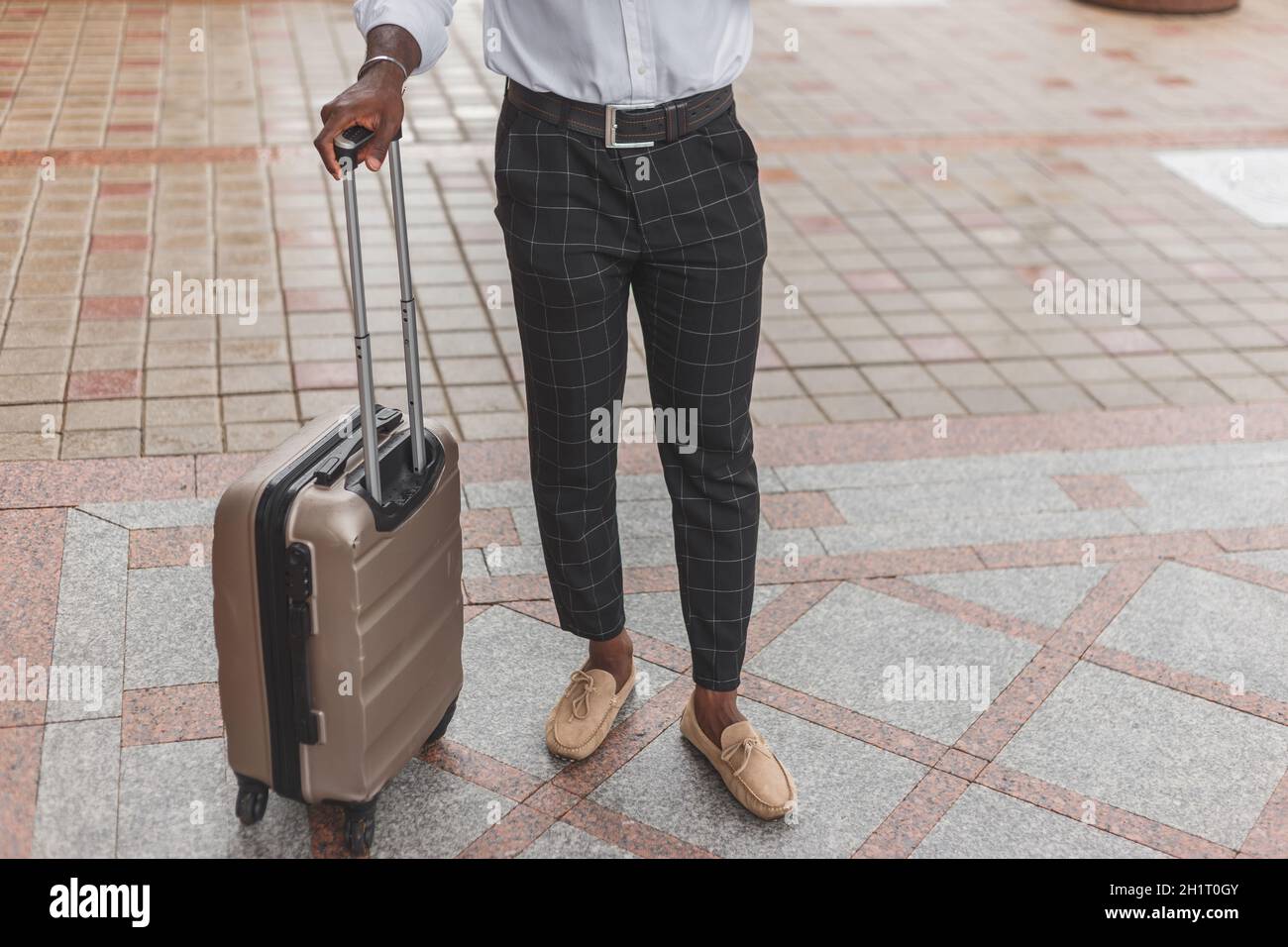 Stilvoll gekleideter schwarzer Kerl mit Gepäck im Freien. Stockfoto