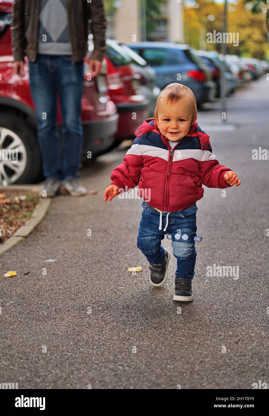 Kleiner Junge, der seine ersten Schritte die Straße hinunter unternimmt Stockfoto