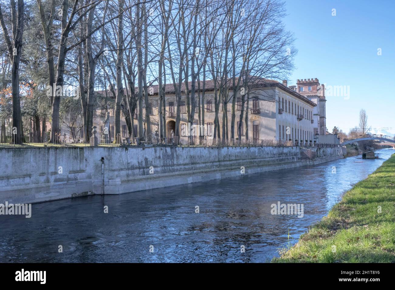 Ansicht der alten Villa und den patk mit riesigen Bäumen am Ufer des künstlichen historische Kanal, im Winter helles Licht bei Robecco sul Naviglio, Mi shot Stockfoto