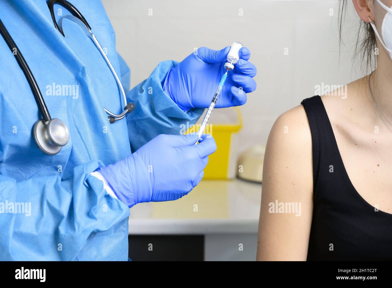 Nahaufnahme einer jungen Frau mit schützender Gesichtsmaske, die geimpft wird, Coronavirus-Konzept. Hochwertige Fotos Stockfoto