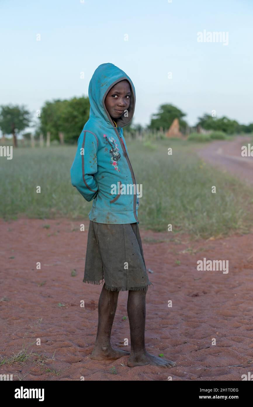 NAMIBIA, REGION OMUSATI, MAI 7: Afrikanisches Mädchen am frühen kalten Morgen auf dem Weg in die Stadt Opuwo. Nord-Namibia, 6. Mai 2018, Namibia Afrika Stockfoto