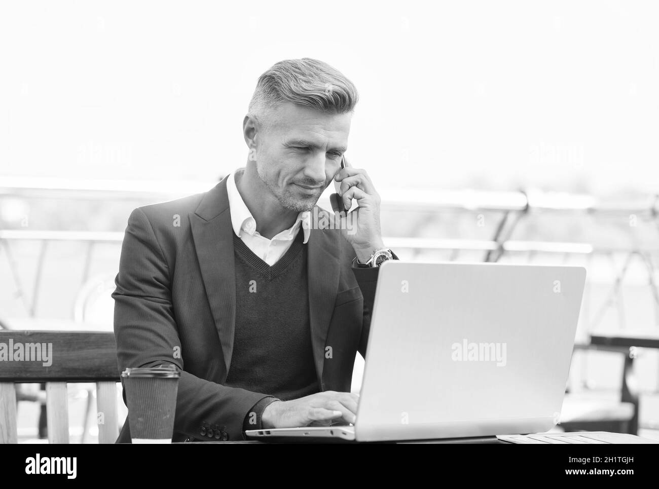 Kommerzielle Mitarbeiter tätigen Telefongespräche mit dem Laptop im Internet-Café im Freien, Konferenz Stockfoto