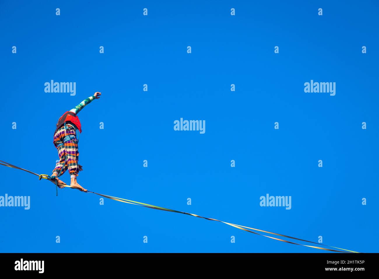 LANZO, ITALIEN - CA. OKTOBER 2020: Slackline-Athlet während seiner Performance. Konzentration, Balance und Abenteuer in diesem dynamischen Sport. Stockfoto