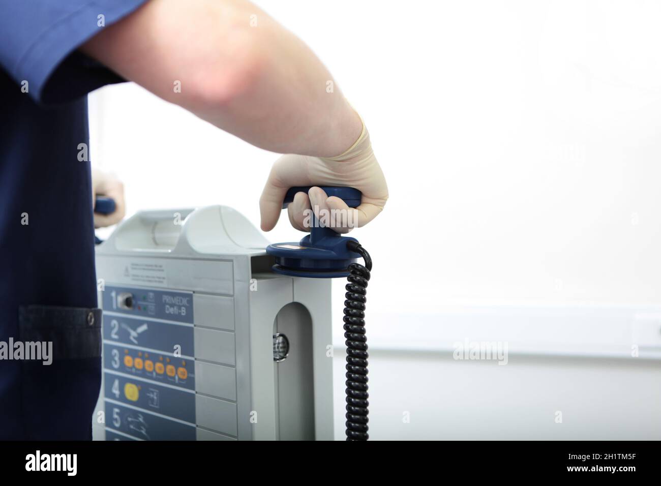 Der Beatmungsgerät hält eine Elektrode in der Hand. Vorbereitung der Defibrillation. Ausstattung einer modernen Klinik. Lebensrettendes Konzept. Mehr als Anerkennung. Stockfoto