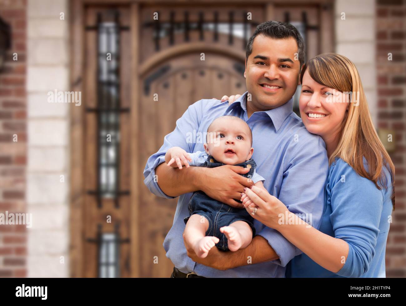 Happy Mixed Race Paar mit Baby vor dem Haus. Stockfoto