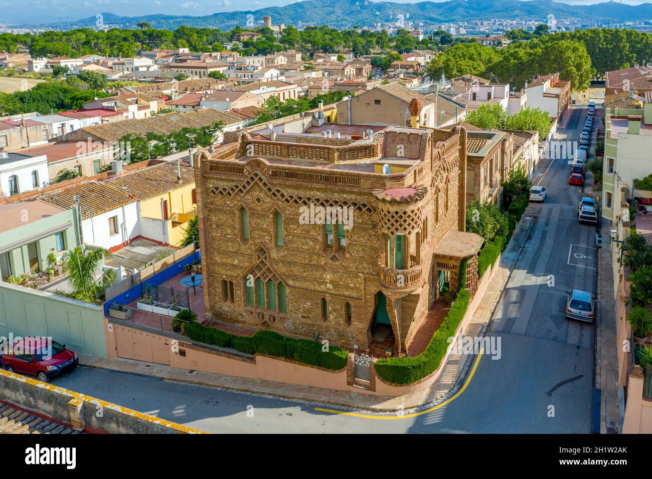 Colonia Guell, Spanien - 27. August 2020: Eines der alten roten Ziegelhäuser in der Kolonie Guell an einem klaren, sonnigen Tag. Eine Probe des Architekten von Spanien Stockfoto