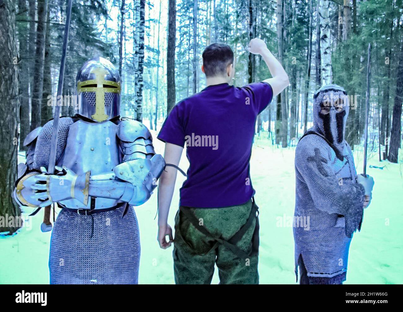 Ritter in Rüstung, Post und Schwert mitten im Winterwald. Der Mann im Hemd zwischen den Rittern. Klassische Militäruniform. Stockfoto