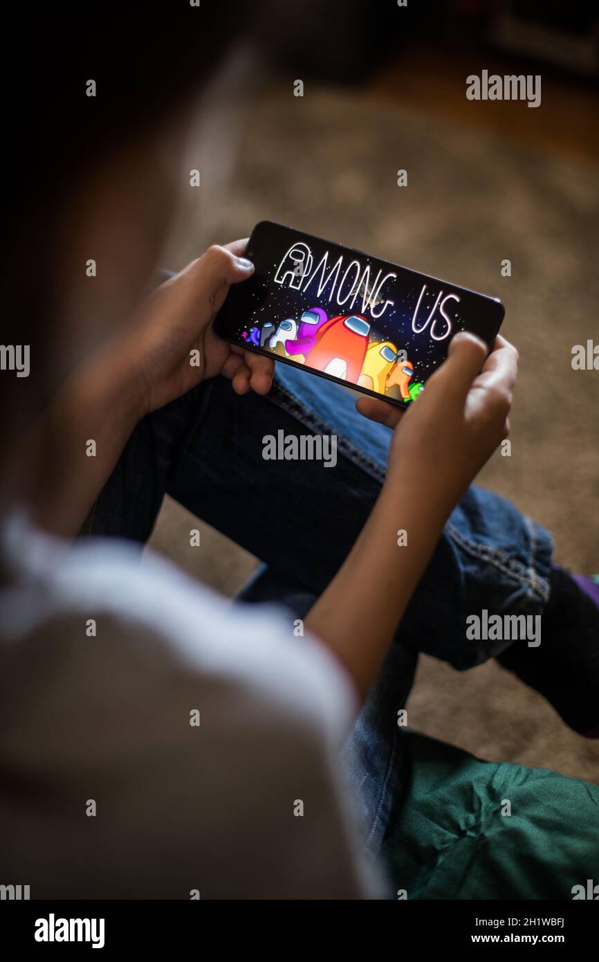 Bukarest, RUMÄNIEN - 10. Mai 2021: Illustratives redaktionelles Konzept Bild eines Kindes, das unter uns ein Spiel auf einem Mobiltelefon spielt. Stockfoto