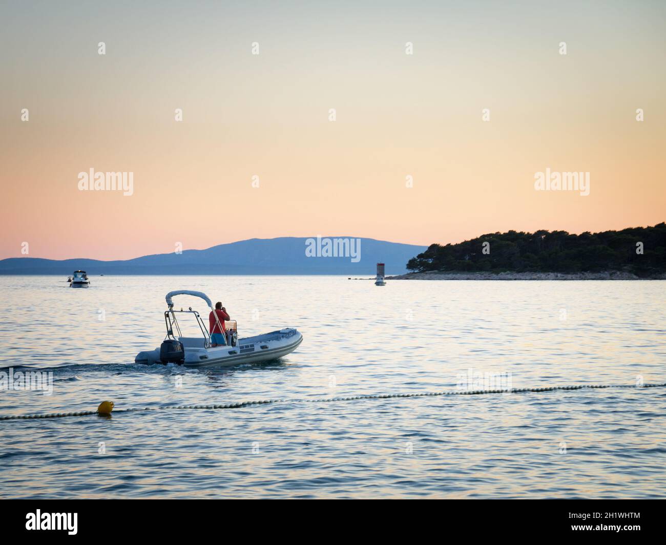 Mann auf einem Motorboot, der auf seinem Mobiltelefon spricht Stockfoto