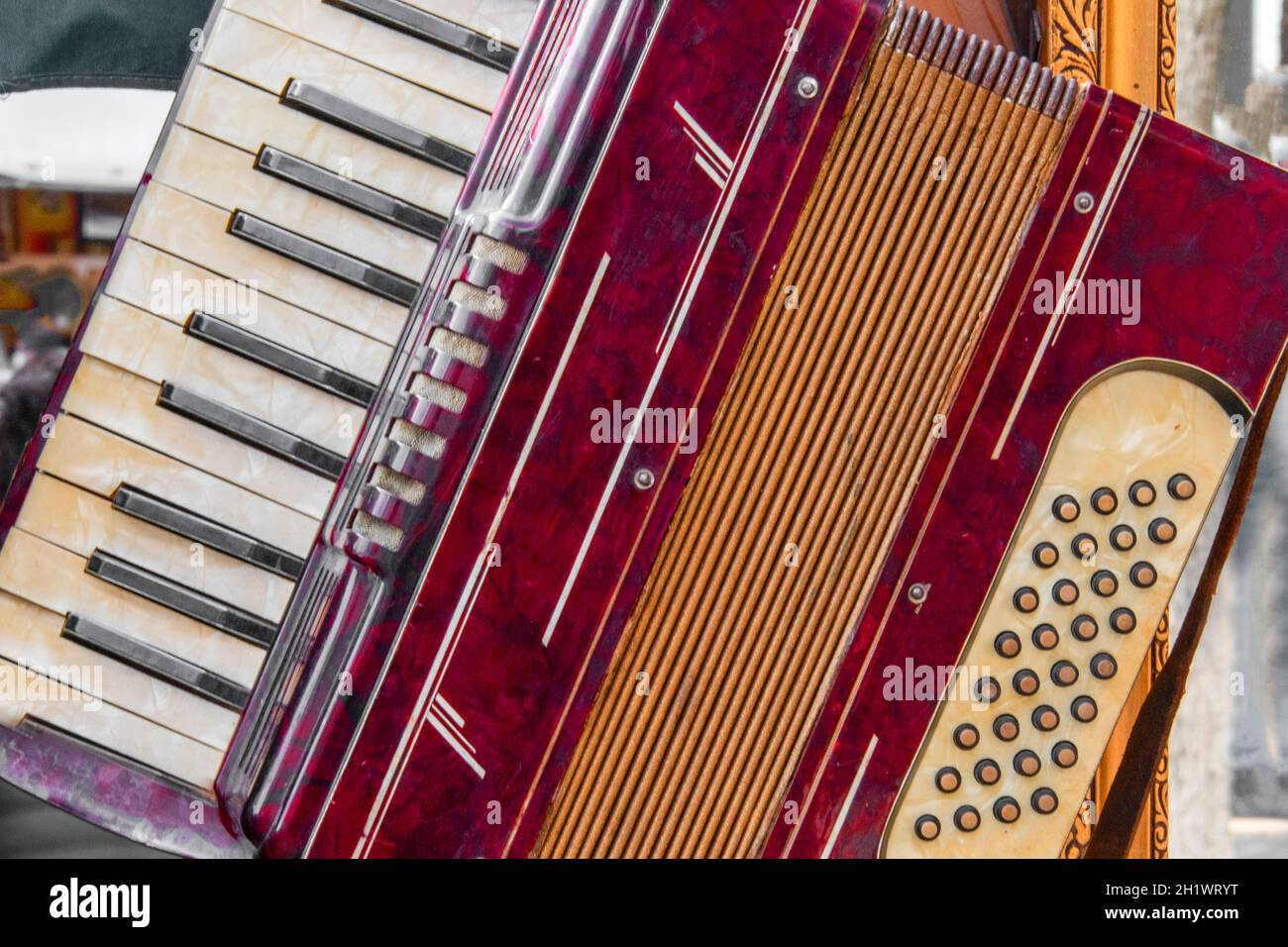 Teilansicht einer alten roten Ziehharmonika mit musikalischer Tastatur und Knöpfen Stockfoto
