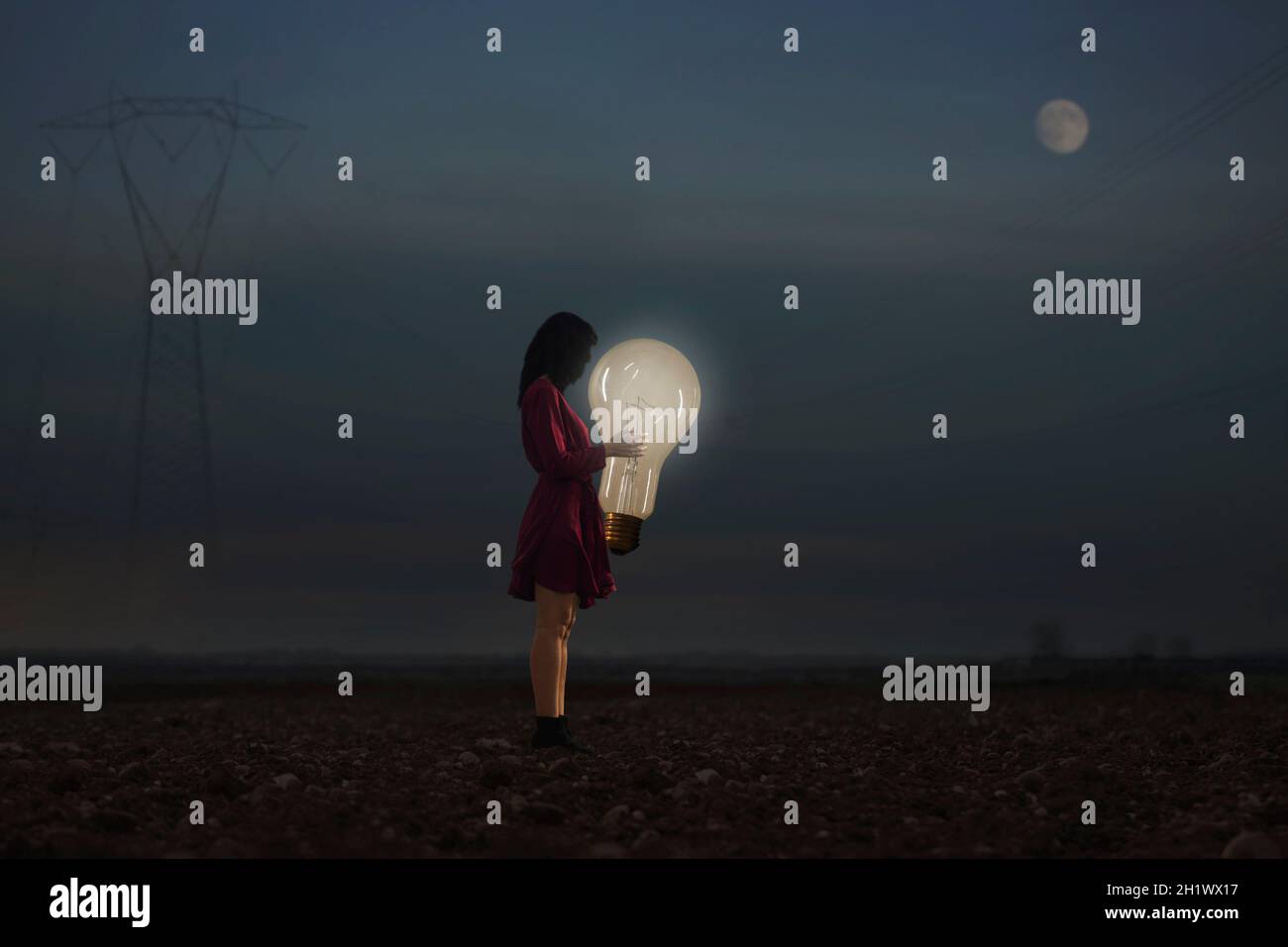 Frau umarmt eine ihrer kreativen Ideen, die die Nacht aufleuchten lassen Stockfoto