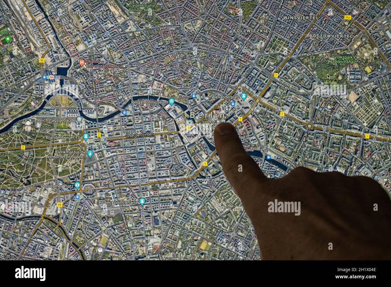 Udine, Italien. 21. August 2021. Die Google Maps-Satellitenansicht von Berlin, der Hauptstadt Deutschlands, wird mit einem Finger angezeigt Stockfoto