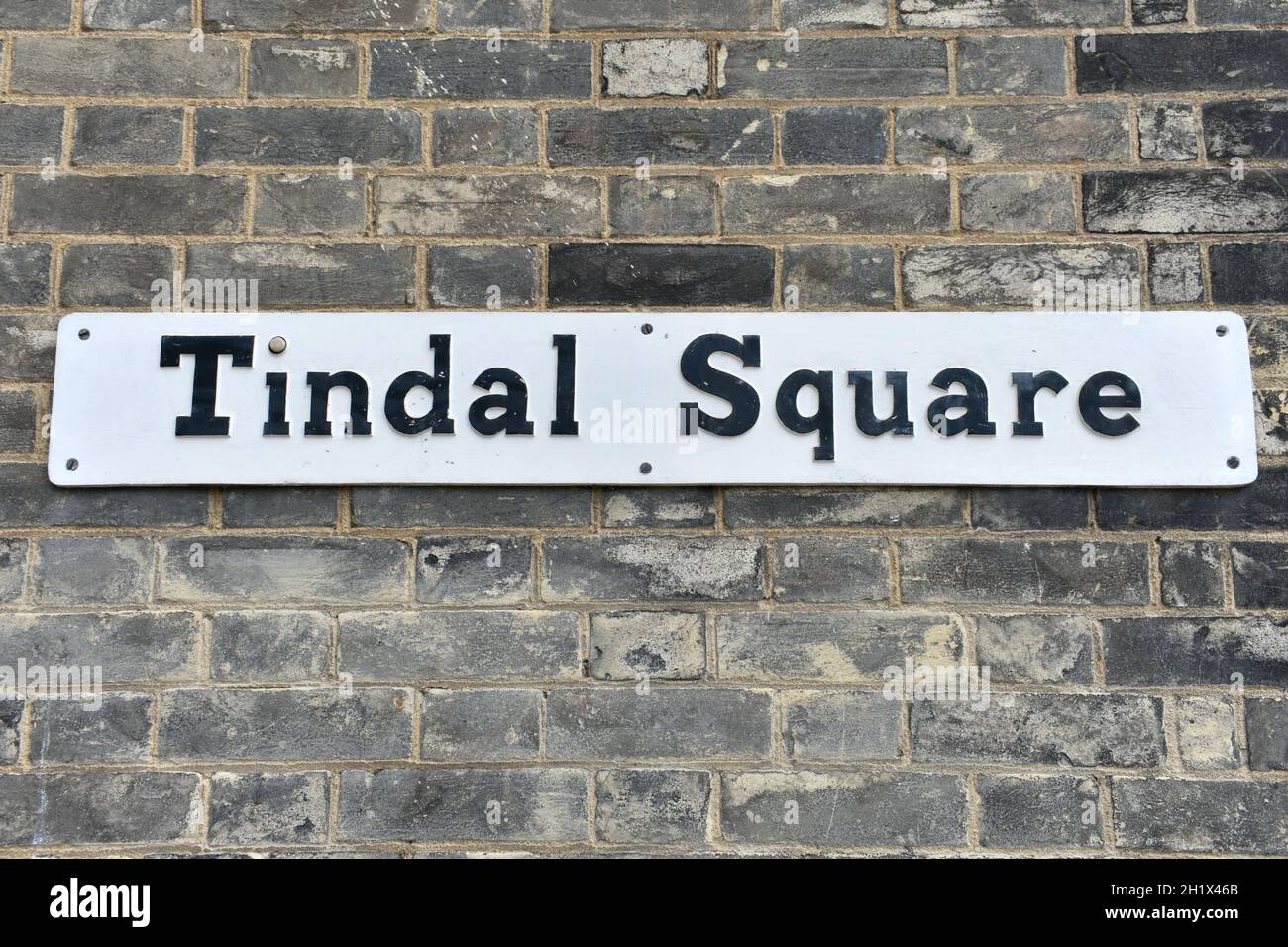 Nahaufnahme längliches Metallschild mit aufgedruckten Wörtern - Tindal Square. Hinweisschild an einer Steinmauer eines Gebäudes in einer Stadtstraße draußen im Trockenen angebracht Stockfoto