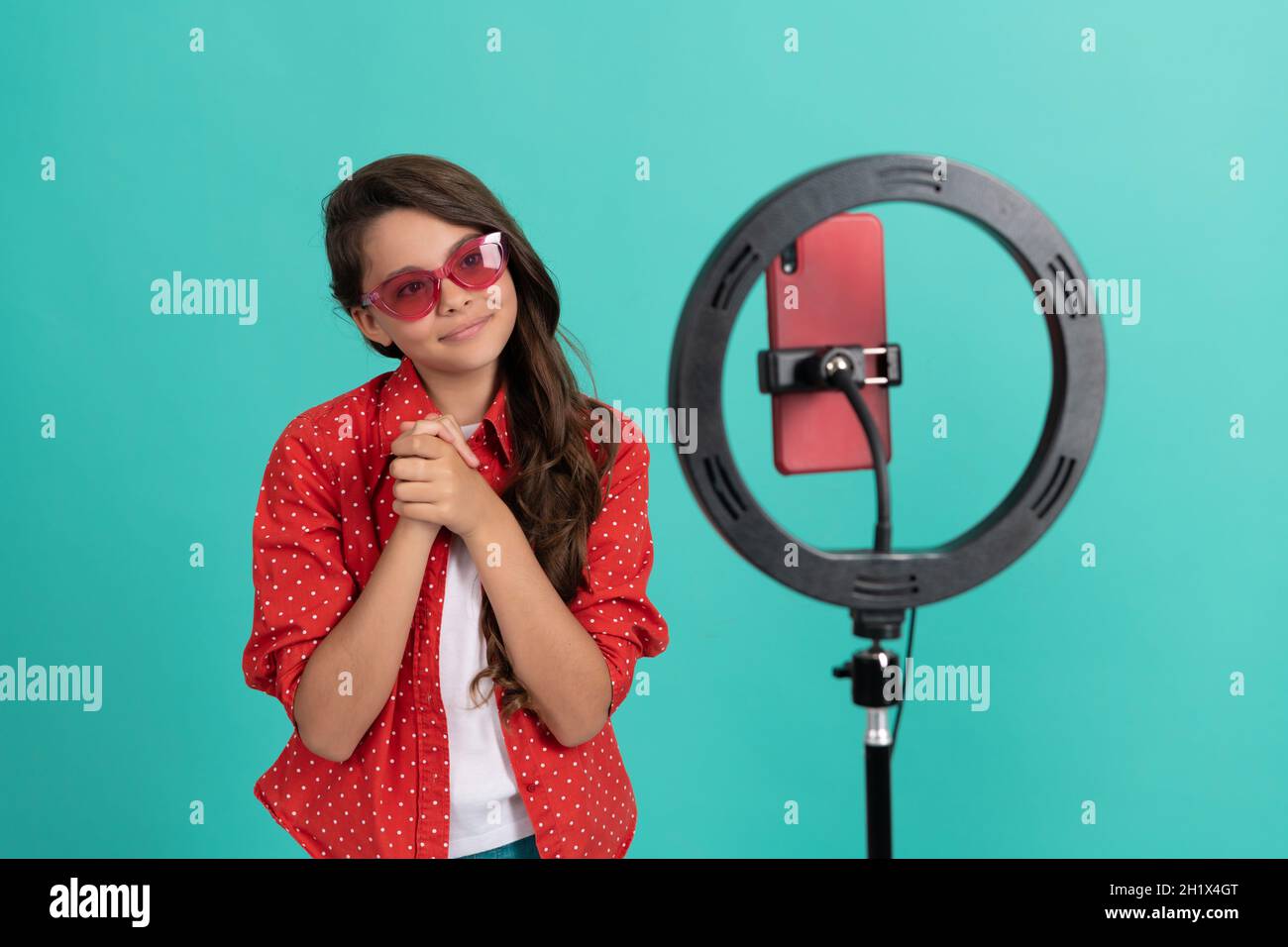 Lächelndes Teenager-Mädchen lange Haare in Sonnenbrillen Bloggen online mit Selfie geführt, Influencer. Stockfoto