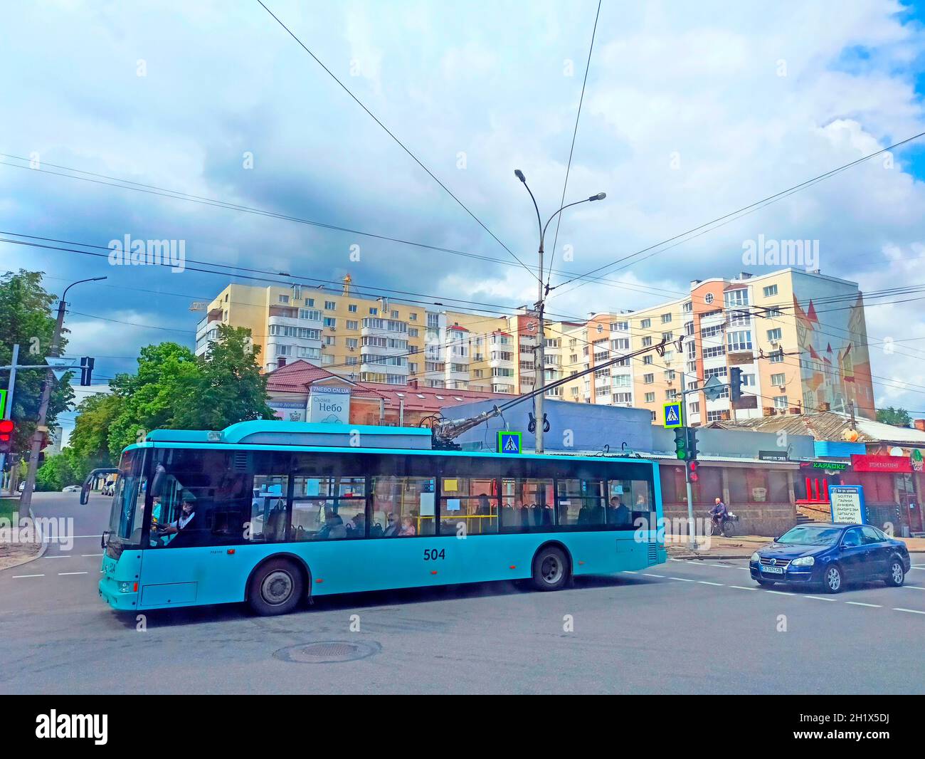 Trolley-Bus fährt entlang der Stadtstraße. Viel Verkehr in der Stadt Tschernihiv. Stadtverkehr und Autos. Öffentliche Verkehrsmittel auf der Straße der Stadt. Blauer Obus dr Stockfoto