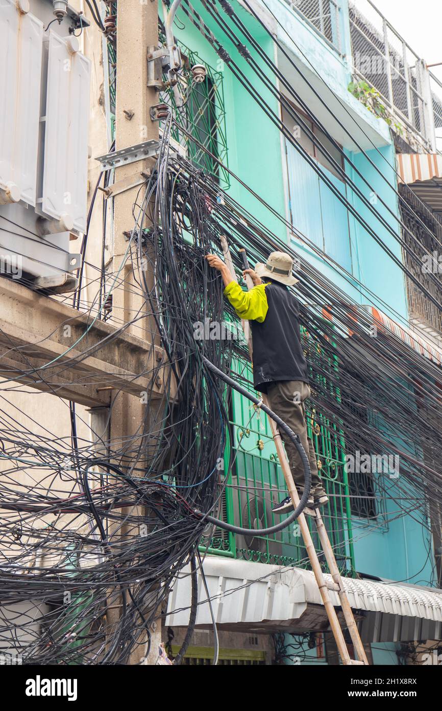 Ein Elektriker bei seiner täglichen Arbeit in Bangkok, Thailand, Südostasien Stockfoto