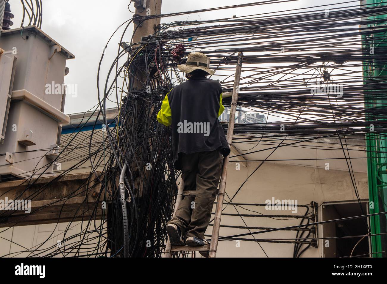 Ein Elektriker bei seiner täglichen Arbeit in Bangkok, Thailand, Südostasien Stockfoto