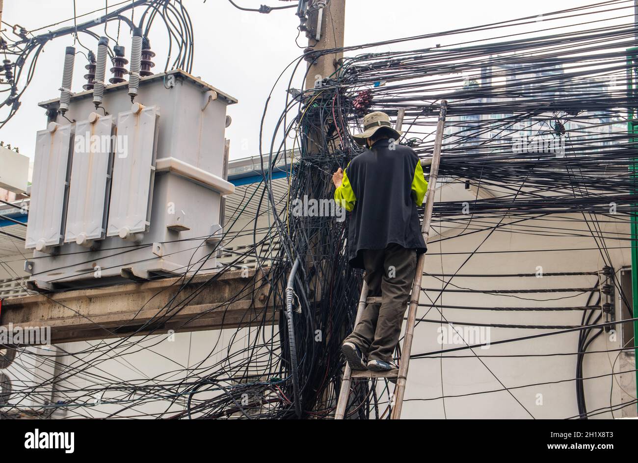 Ein Elektriker bei seiner täglichen Arbeit in Bangkok, Thailand, Südostasien Stockfoto