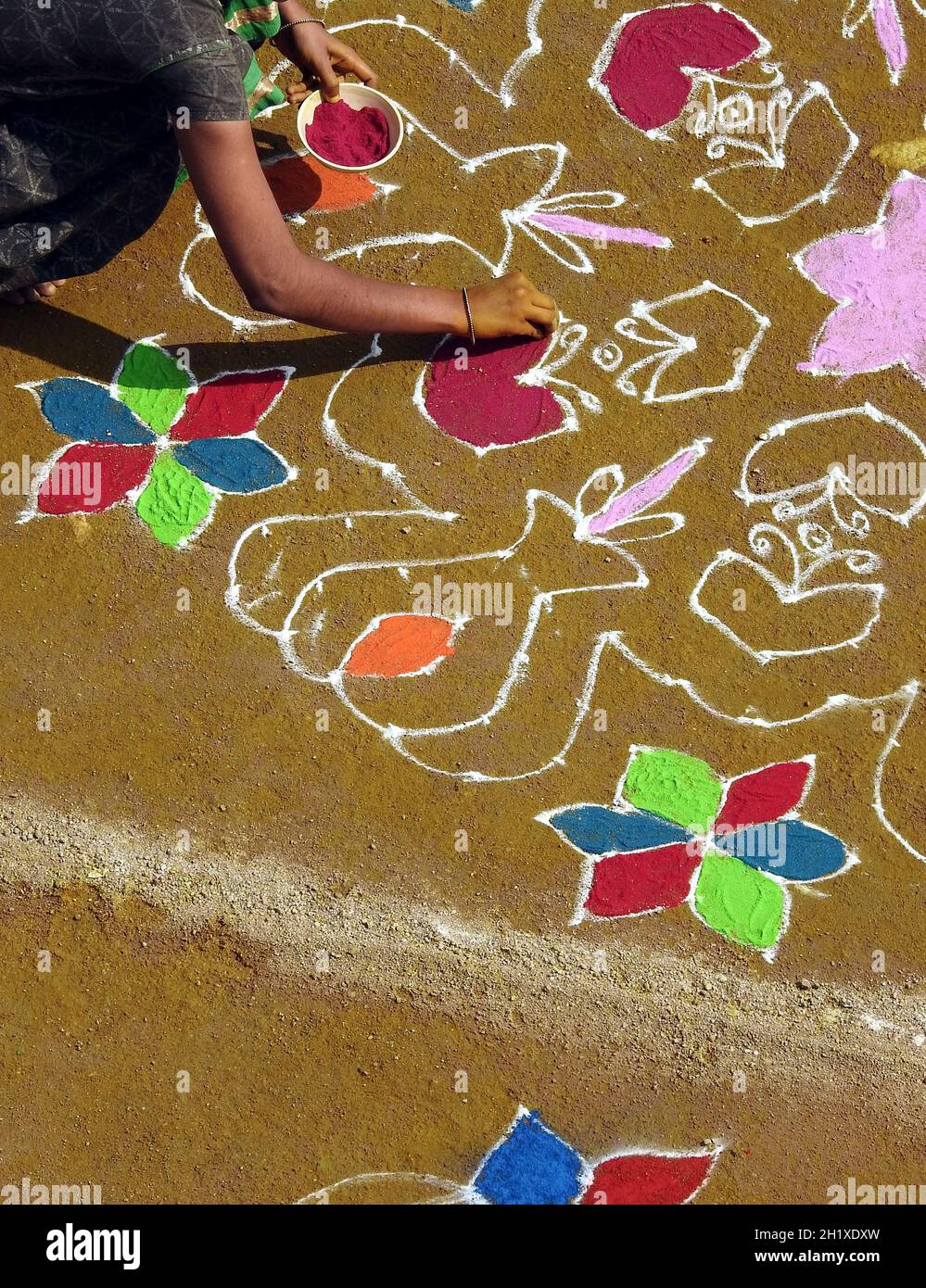 Indische Frau, die Rangoli vor Haus oder Tempel zeichnet Während der Ernte Festival pongal oder makar sankranti Stockfoto