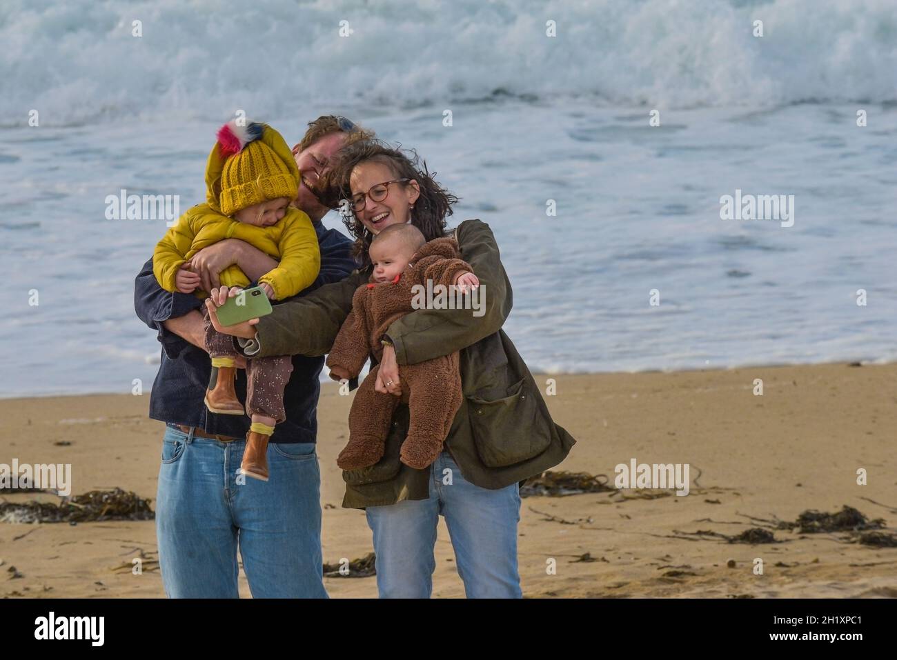 Eine Familie, die Spaß hat, ein Selfie mit einem Mobiltelefon am Fistral Beach in Newquay in Cornwall zu machen. Stockfoto
