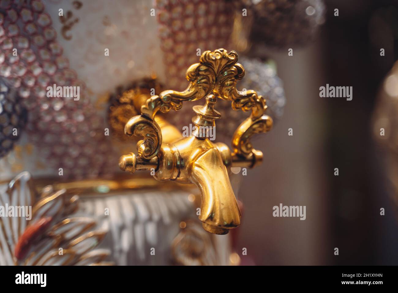 Perspektivische Ansicht Nahaufnahme von schönen vergoldeten Hahn mit Keramikgriff aus luxuriösem Glas samovar Stockfoto