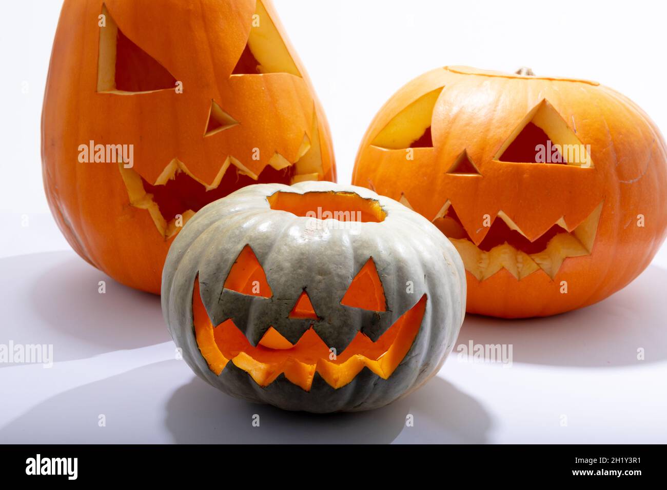 Komposition aus drei halloween geschnitzten Kürbissen mit Kopierfläche auf weißem Hintergrund Stockfoto