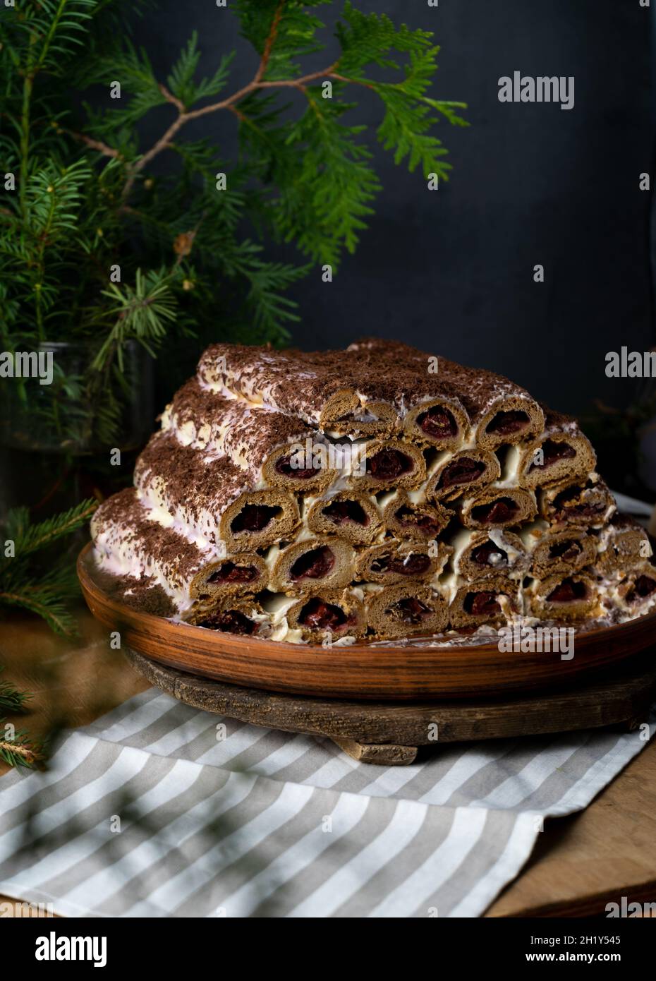 Mönchshütte-Kuchen. Hausgemachte Kuchen, süßer Kuchen mit Kirschfüllung und Rahm. Aus Rohren gesammelt, wird der Teig gerollt. Kuchen auf dem Tisch. Festliche Speisen zum Nachtisch Stockfoto