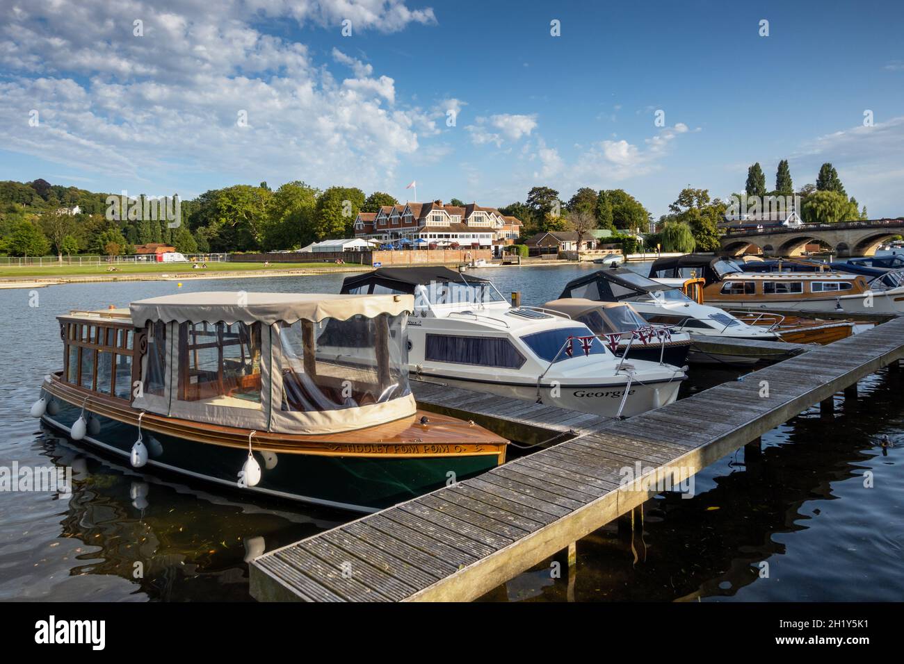 Die Boote vertäuten auf der Themse bei Henley on Thames in Oxfordshire. Auf der gegenüberliegenden Bank (Remenham) befindet sich das Gebäude des berühmten Leander Rowing Club Stockfoto