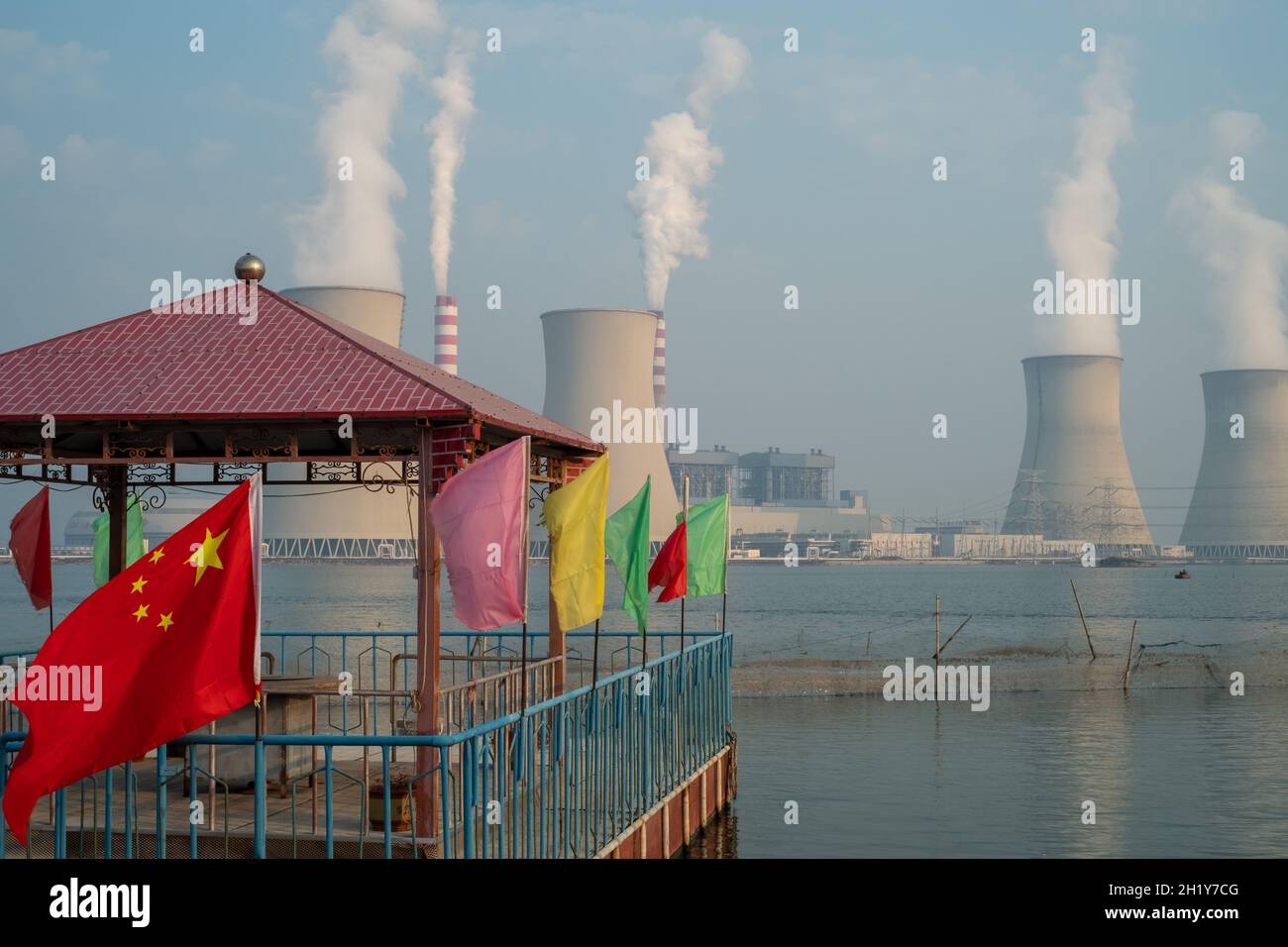 Die chinesische Flagge, die einen Pavillon schmückt, ist vor einem Kraftwerk in Tianjin, China, zu sehen. 19-Okt-2021 Stockfoto