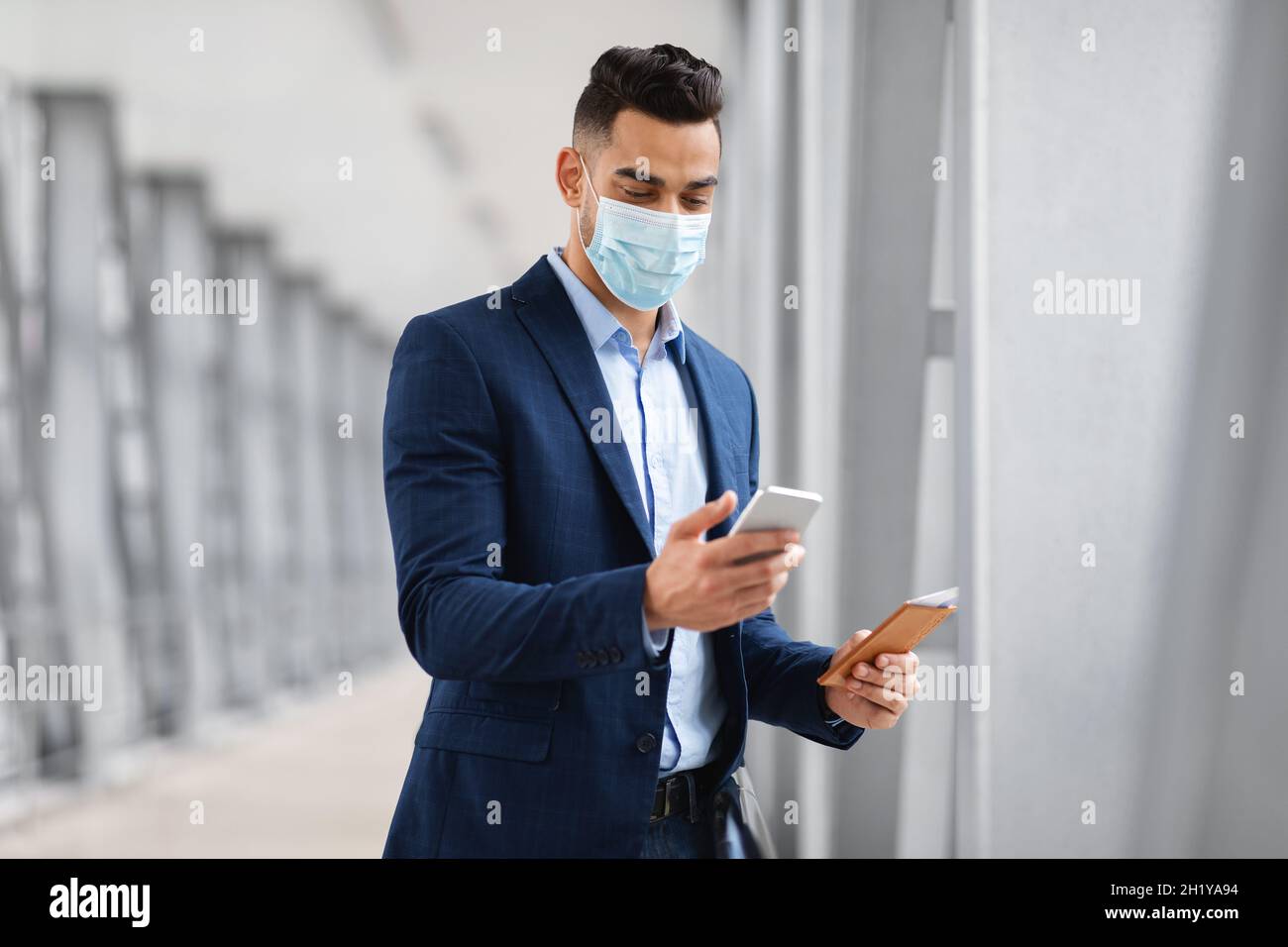 Naher Osten Geschäftsmann Trägt Medizinische Maske Mit Smartphone Am Flughafen Stockfoto