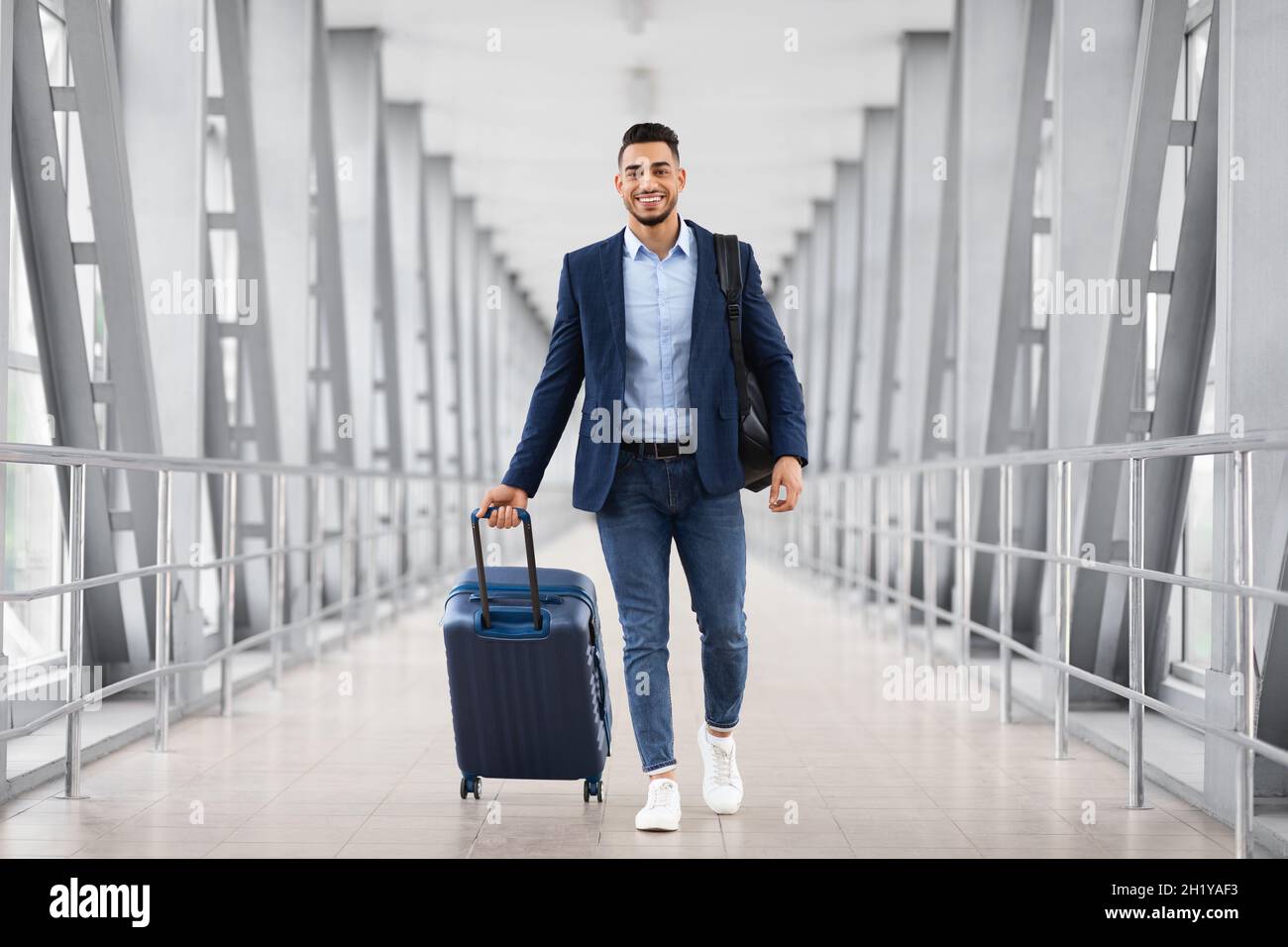 Flugreisen. Porträt Eines Lächelnden Arabischen Mannes, Der Am Flughafen Mit Gepäck Unterwegs Ist Stockfoto