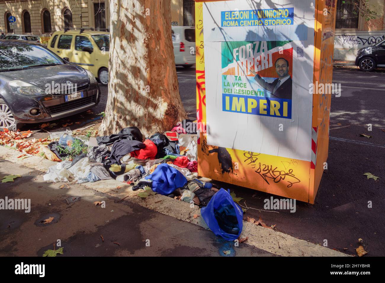 Mülltonne in Rom, Italien mit Plakat des Kandidaten für Kommunalwahlen. Müll verbreitete sich auf den Straßen der römischen Hauptstadt vor dem Müllcontainer und lag auf der Straße. Stockfoto