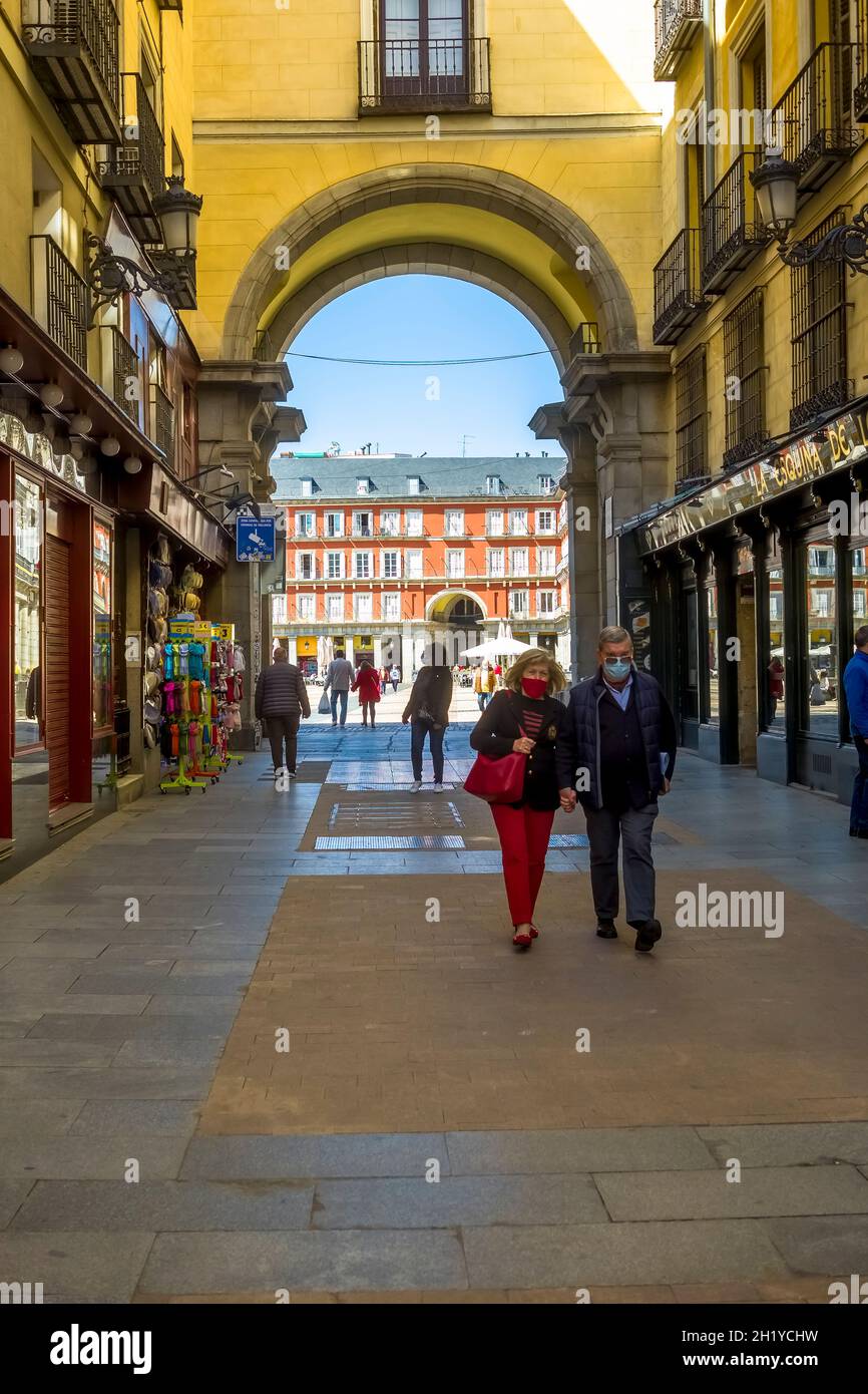 Blick auf die Silhouette der Menschen, die von der Calle de la Sal in Madrid aus auf die Plaza Mayor unter dem Arch gehen. Stockfoto